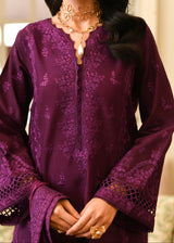 Purple embroidered outfit with gold jewelry on a blurred background