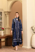 Woman wearing a blue embroidered outfit in an elegant indoor setting