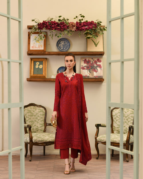 Woman in a red outfit standing in a room with decorative shelves and chairs.