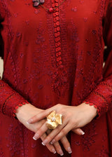 Red embroidered dress with a gold ring on a hand