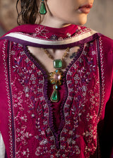 Close-up of a person wearing a red embroidered garment with jewelry.