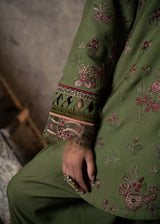 Green embroidered garment with floral patterns on a textured surface